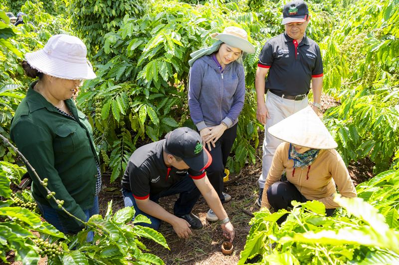 Cán bộ hỗ trợ nông nghiệp của Nestlé Việt Nam hướng dẫn nông dân trồng cà phê thực hành canh tác nông nghiệp tái sinh. Ảnh: Nestlé