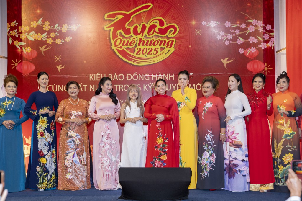 Nhà thiết kế Trần Phương Hoa (thứ 5 từ trái sang) cùng bà con kiều bào trình diễn áo dài tại sự kiện