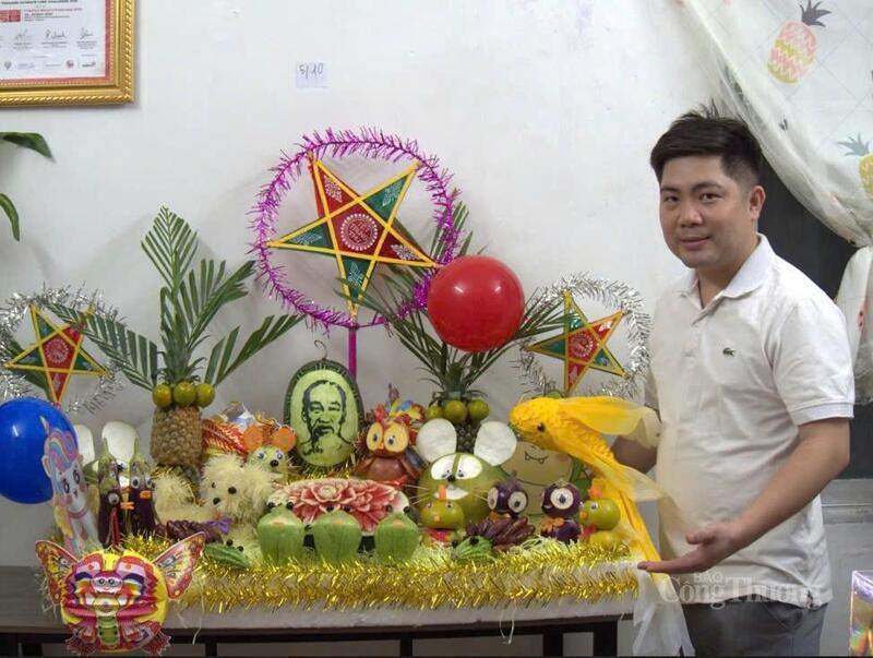 Nghệ nhân Lưu Đình Việt cùng sản phẩm mâm cỗ Trung thu vừa trưng bày.
