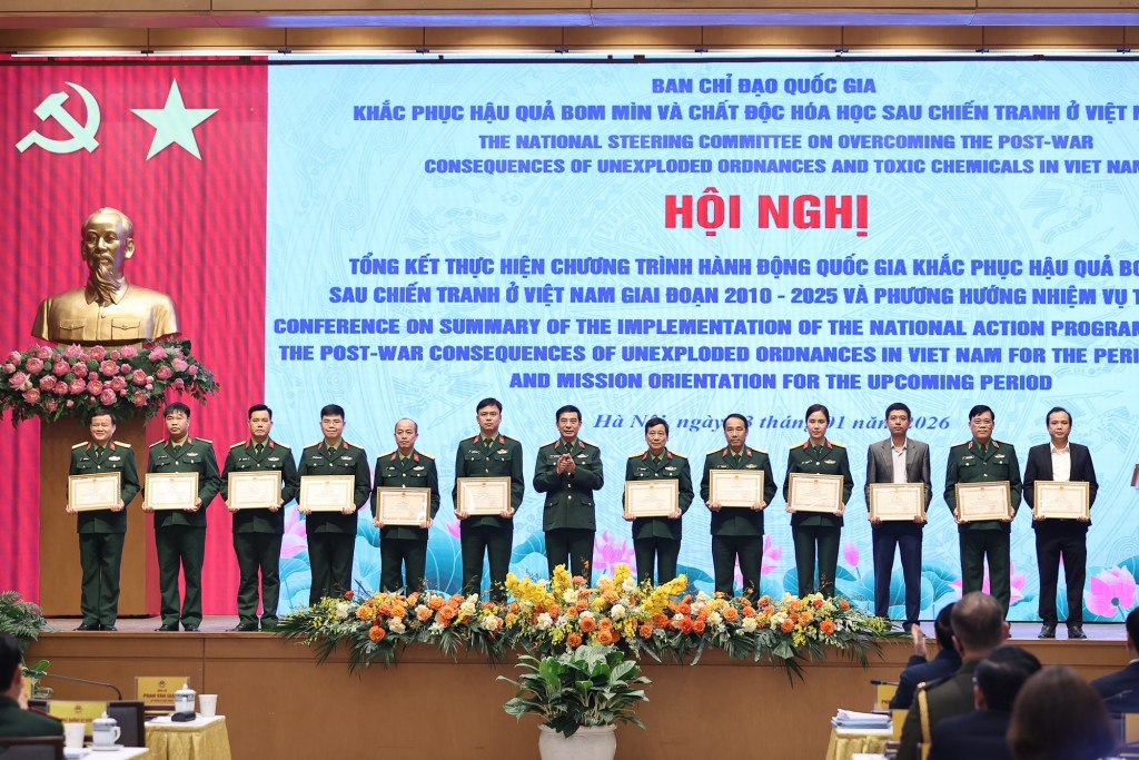 Bộ trưởng Bộ Quốc phòng Phan Văn Giang trao bằng khen của Bộ trưởng Bộ Quốc phòng cho các tập thể, cá nhân có thành tích xuất sắc trong công tác khắc phục hậu quả bom mìn - Ảnh: VGP/Nhật Bắc