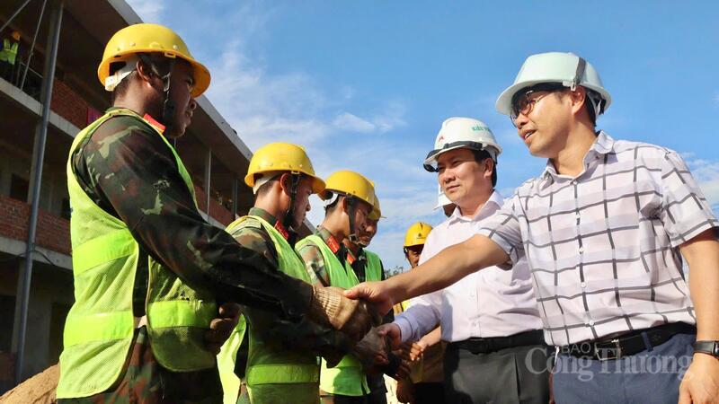 Ông Phạm Xuân Điệp, Giám đốc Ban Quản lý dự án đầu tư xây dựng tỉnh (bên phải) bắt tay động viên nhân công đang thi công tại công trường. Ảnh: Hoàng Phát